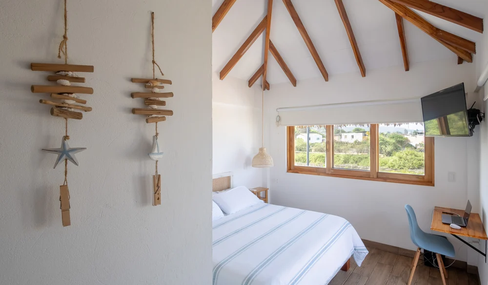Habitación con cama queen, escritorio y detalles de madera
