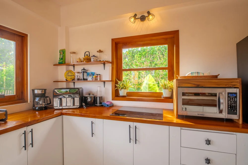 Cocina equipada con cafetera, microondas y encimera de madera